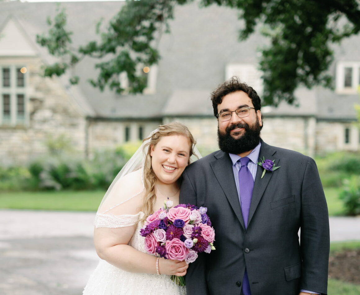 Newlyweds standing next to each other happily.